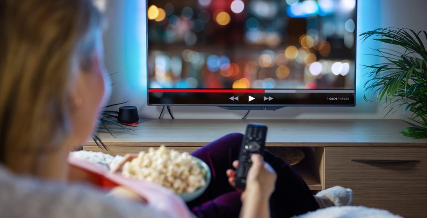 Woman relaxing at home in evening and streaming TV