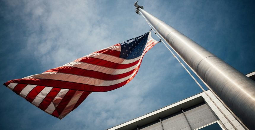 worm's eye view of the american flag flying