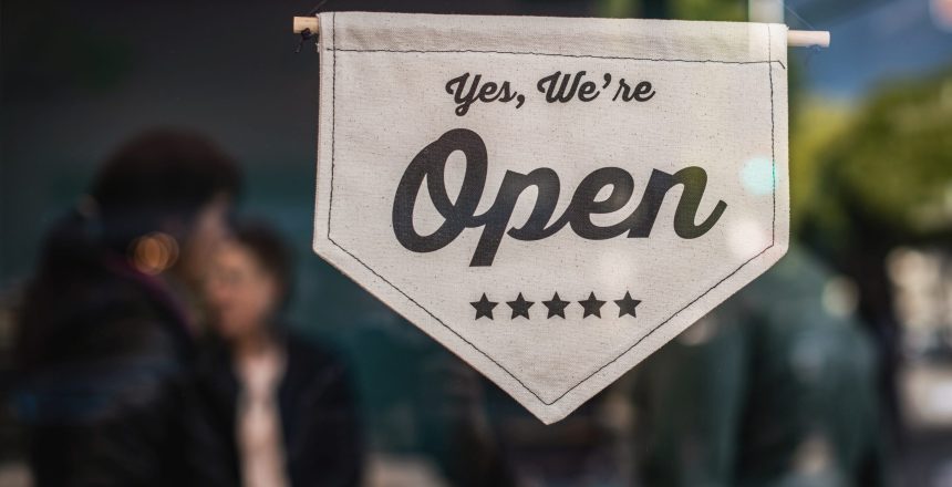 recession proofing: small business shop with "yes. we're open" sign on door