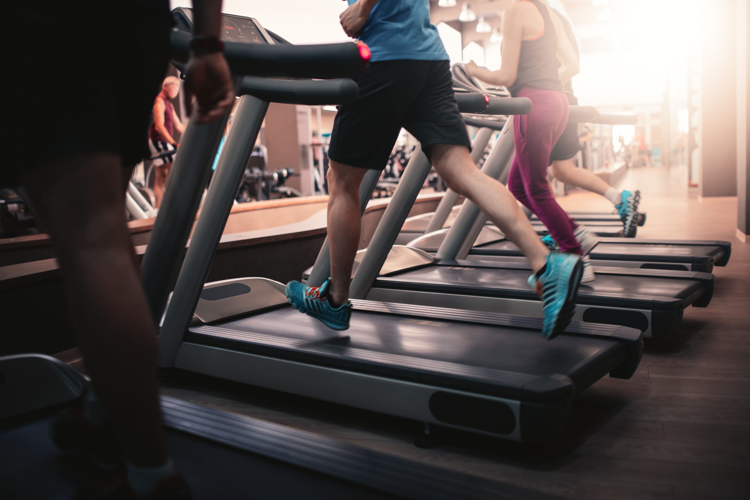 busy gym, people running on treadmill