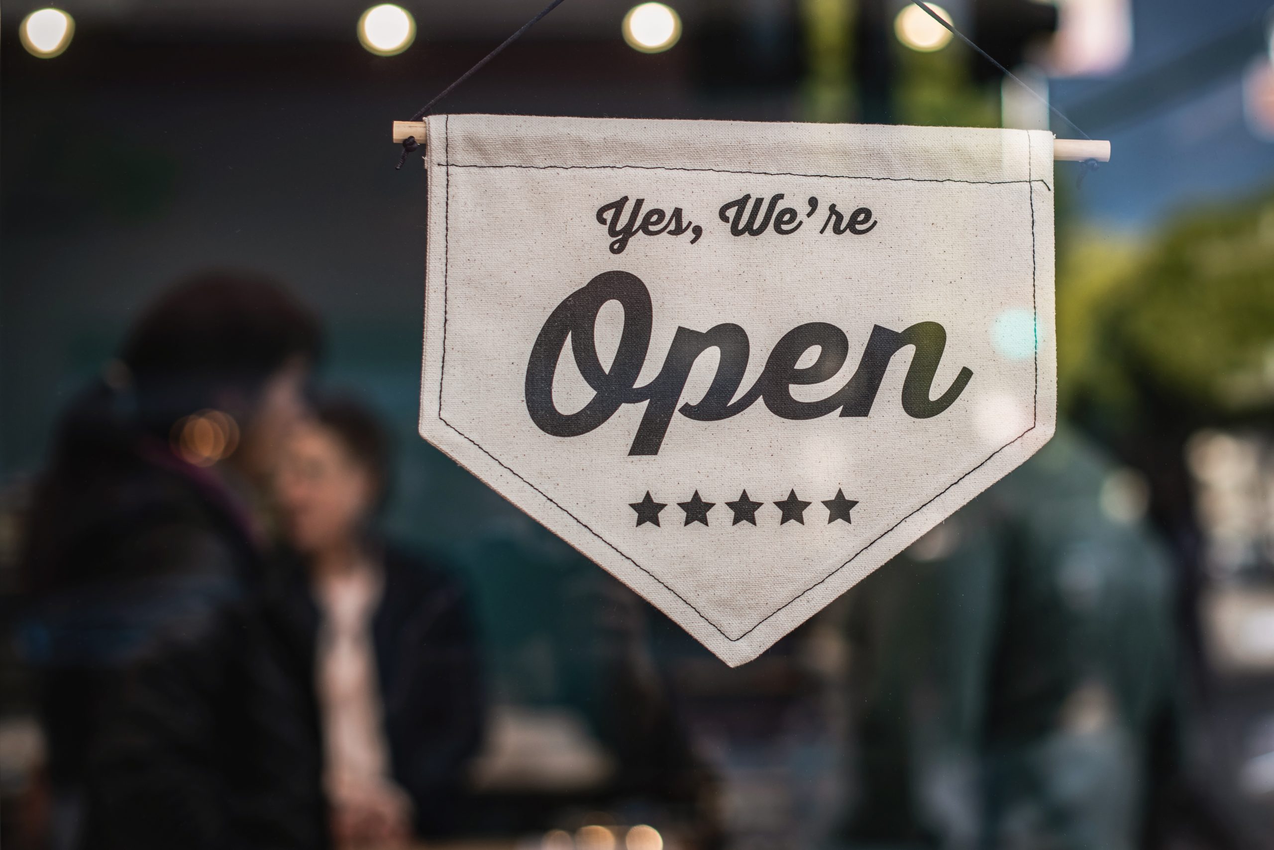 recession proofing: small business shop with "yes. we're open" sign on door